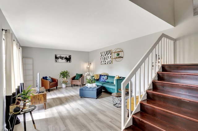 living area featuring stairway and wood finished floors