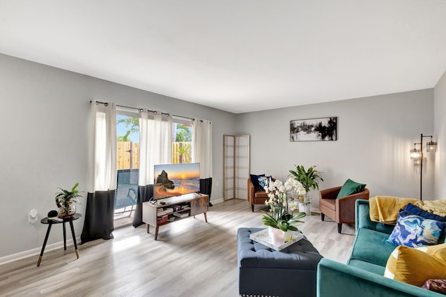 living area featuring light wood-style floors and baseboards