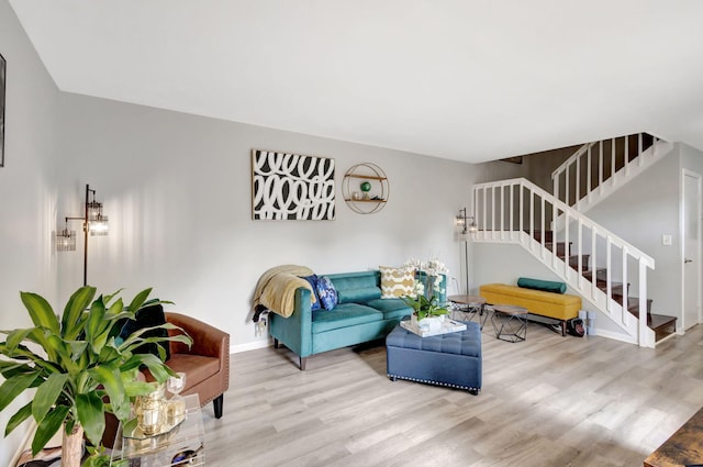 living room with stairs, baseboards, and wood finished floors