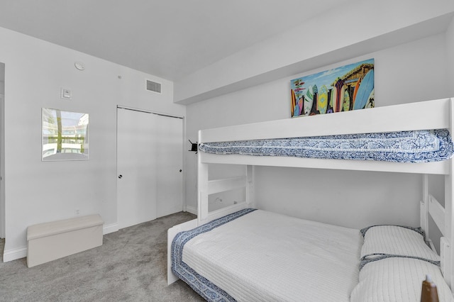 carpeted bedroom with a closet and visible vents