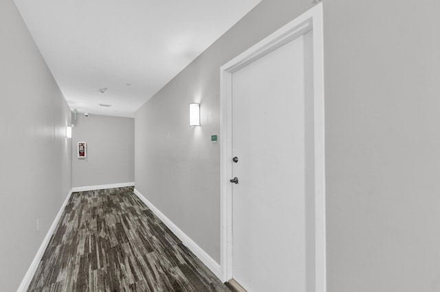 corridor with wood finished floors and baseboards