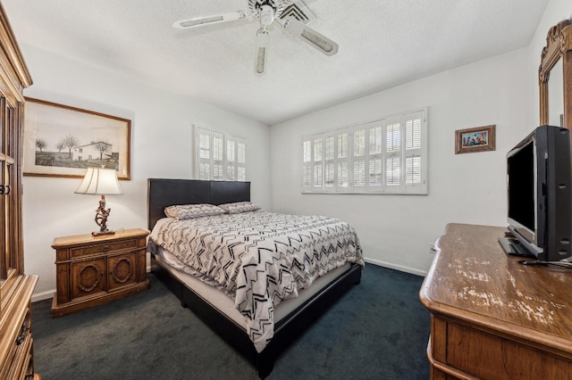 bedroom with a ceiling fan, baseboards, dark carpet, and a textured ceiling