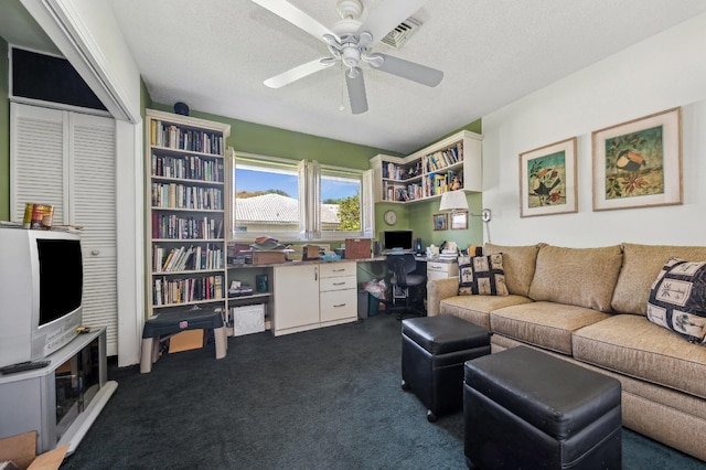 living area with ceiling fan, visible vents, dark colored carpet, and a textured ceiling