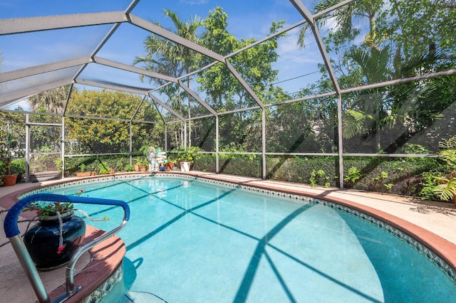 outdoor pool with glass enclosure and a patio area