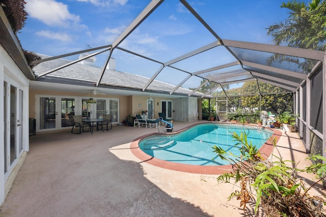 pool with glass enclosure, a ceiling fan, a patio, and french doors