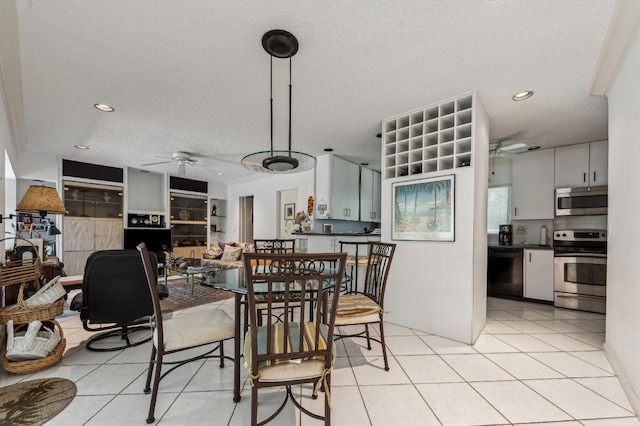 dining space featuring light tile patterned flooring, ceiling fan, and a textured ceiling