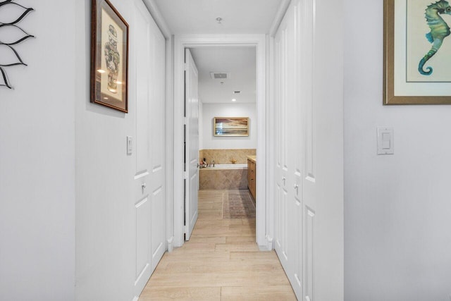 hall with visible vents and light wood-style floors