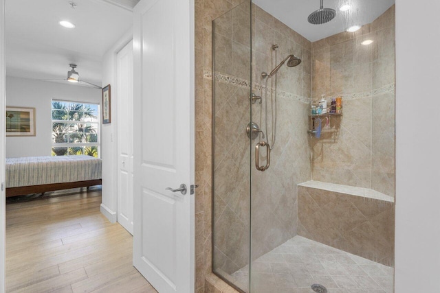 bathroom featuring a stall shower, baseboards, ceiling fan, wood finished floors, and ensuite bathroom