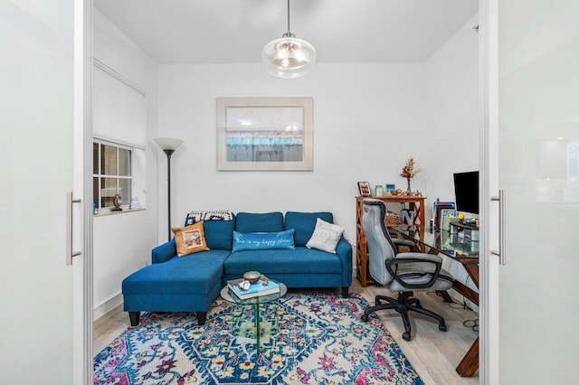 home office with baseboards and wood finished floors