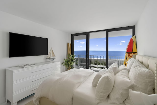 bedroom with access to outside, a wall of windows, and a water view