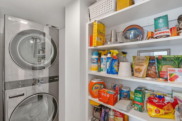 clothes washing area with stacked washer and clothes dryer and laundry area