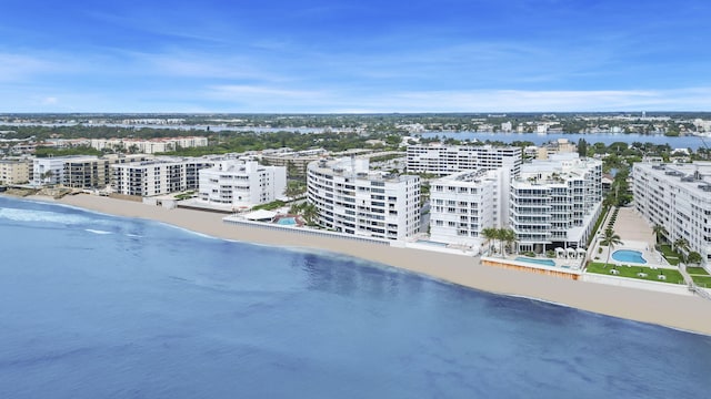 drone / aerial view with a water view, a beach view, and a city view