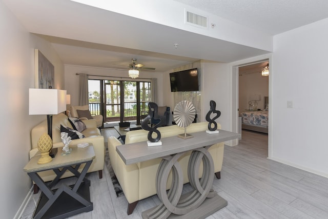 1001 Seafarer Cir Unit 102, Jupiter, FL 33477 - living room featuring ceiling fan, light wood finished floors, and baseboards