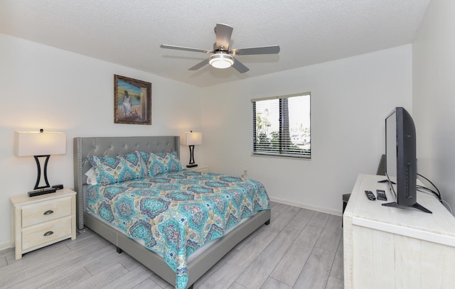 1001 Seafarer Cir Unit 102, Jupiter, FL 33477 - bedroom with light wood-style floors, baseboards, a textured ceiling, and a ceiling fan