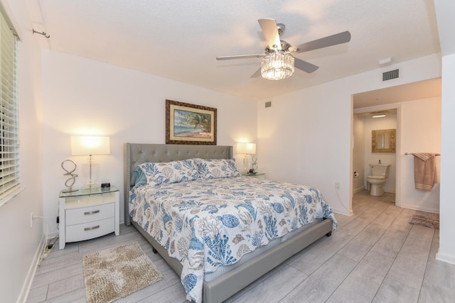 1001 Seafarer Cir Unit 102, Jupiter, FL 33477 - bedroom featuring wood finished floors, baseboards, a ceiling fan, and ensuite bath