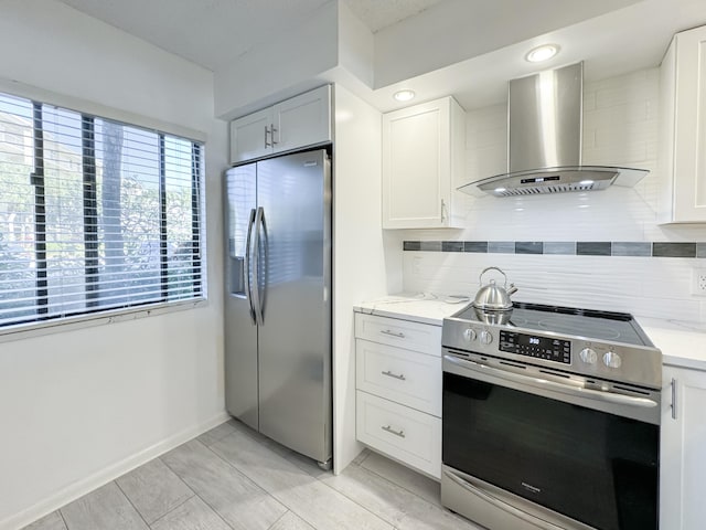 kitchen with light stone counters, stainless steel appliances, backsplash, and wall chimney exhaust hood