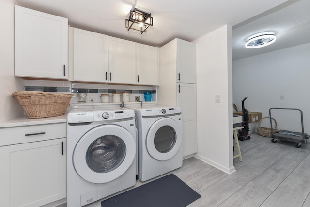 1001 Seafarer Cir Unit 102, Jupiter, FL 33477 - washroom featuring cabinet space, separate washer and dryer, light wood-type flooring, and baseboards
