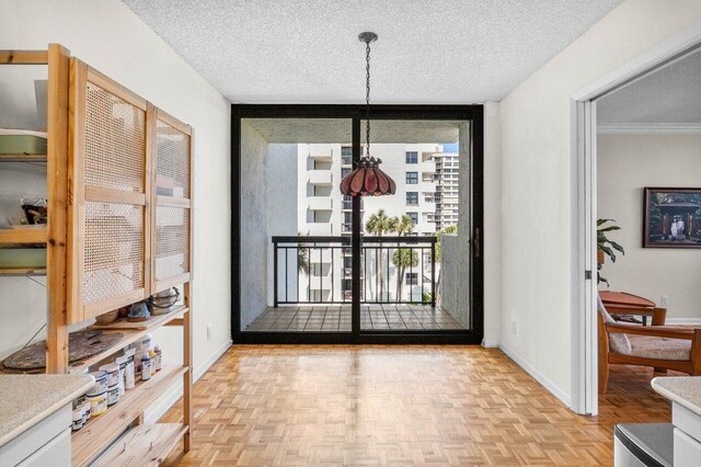 entryway with a textured ceiling, a wall of windows, and baseboards