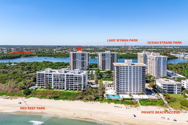 birds eye view of property featuring a water view, a beach view, and a city view