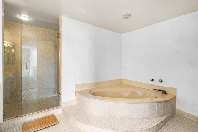 full bathroom featuring a garden tub, a stall shower, and tile patterned flooring