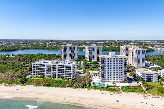 drone / aerial view with a water view, a beach view, and a city view