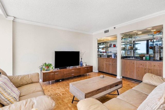 living area featuring ornamental molding, bar area, visible vents, and a textured ceiling