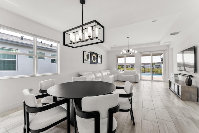 dining space with recessed lighting, a notable chandelier, visible vents, baseboards, and a raised ceiling