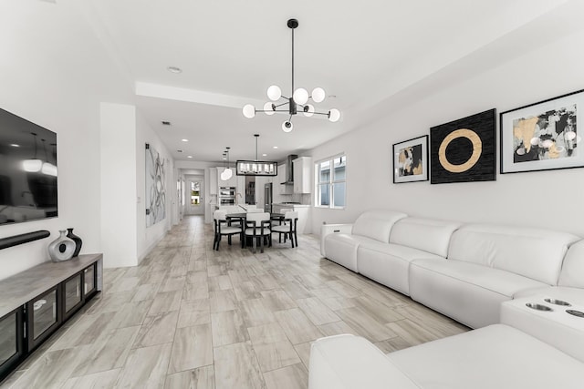 living area with baseboards, recessed lighting, and a notable chandelier