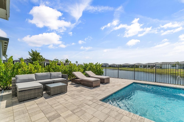 view of swimming pool featuring a water view, a patio, an outdoor living space, and fence