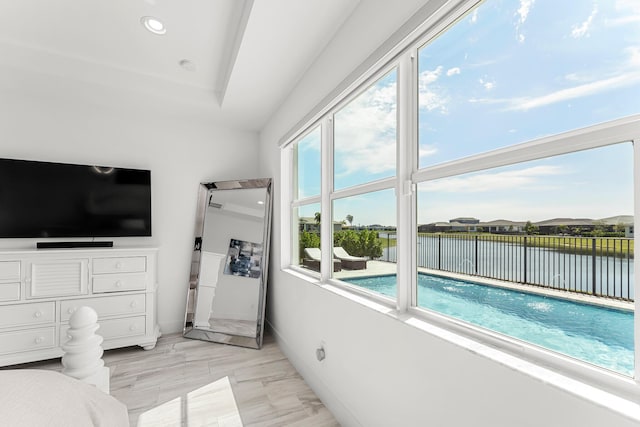 bedroom with recessed lighting, multiple windows, a water view, and baseboards