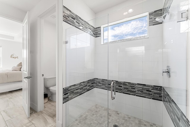 ensuite bathroom with a stall shower, toilet, and ensuite bathroom