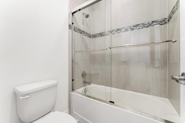 full bathroom featuring combined bath / shower with glass door and toilet