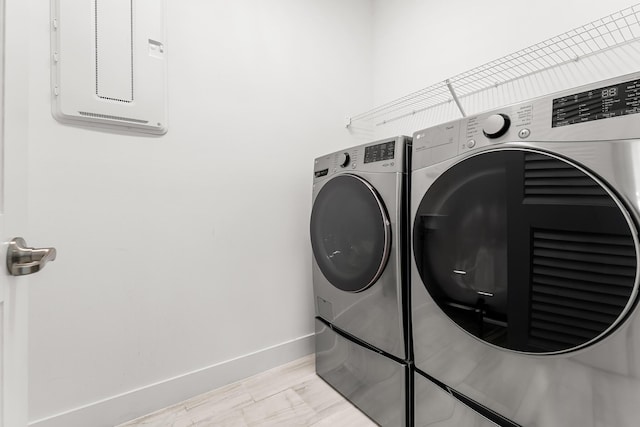 laundry area featuring laundry area, washing machine and dryer, and baseboards