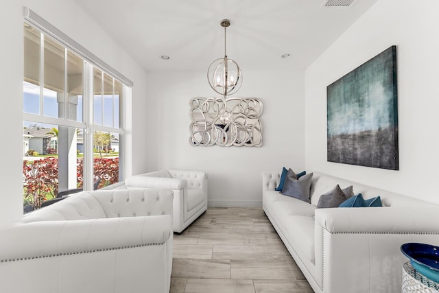 living area with baseboards, visible vents, and an inviting chandelier