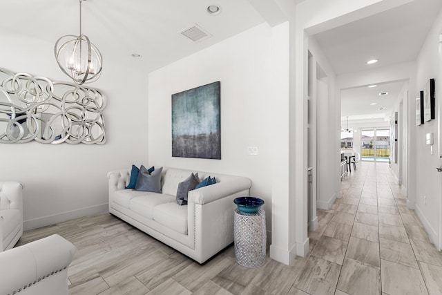 living room with baseboards, recessed lighting, visible vents, and a notable chandelier