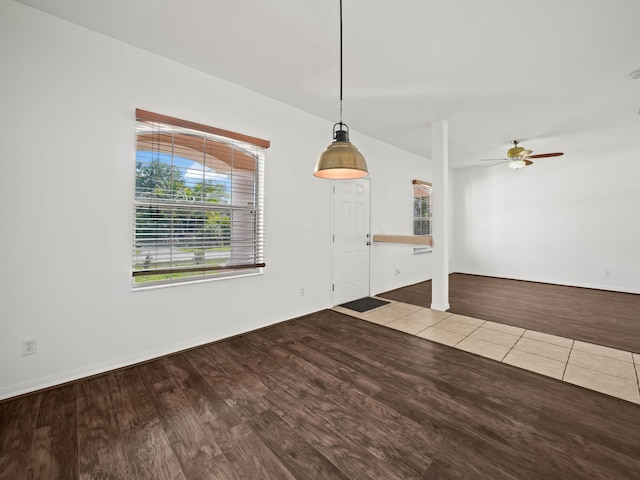 interior space with baseboards, a ceiling fan, and wood finished floors