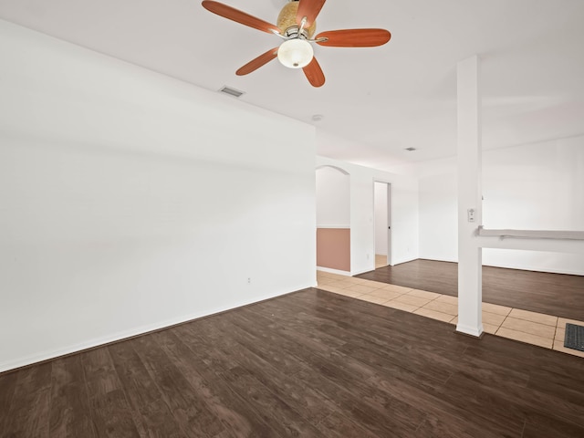 unfurnished room with visible vents, ceiling fan, baseboards, and wood finished floors