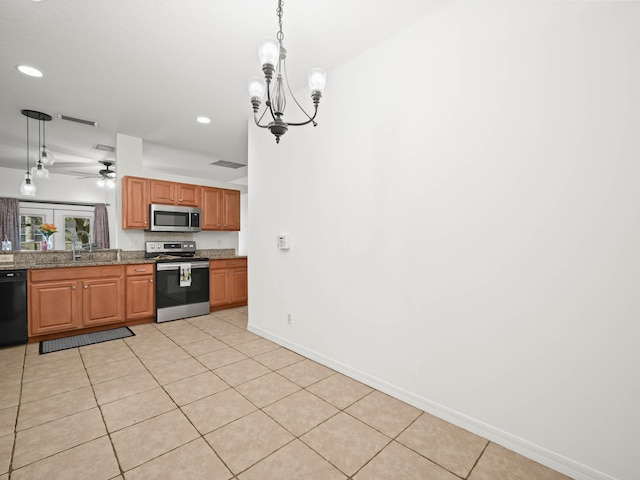 kitchen with hanging light fixtures, light tile patterned floors, baseboards, and stainless steel appliances