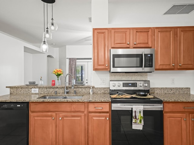 kitchen with light stone counters, a peninsula, a sink, visible vents, and appliances with stainless steel finishes