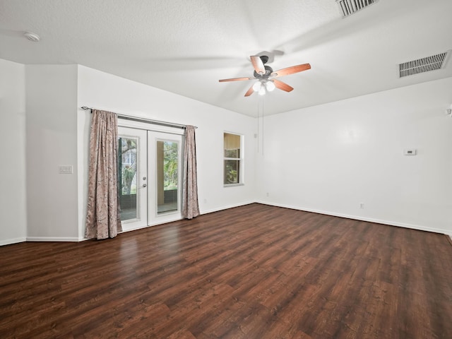 empty room with baseboards, visible vents, dark wood-type flooring, and french doors