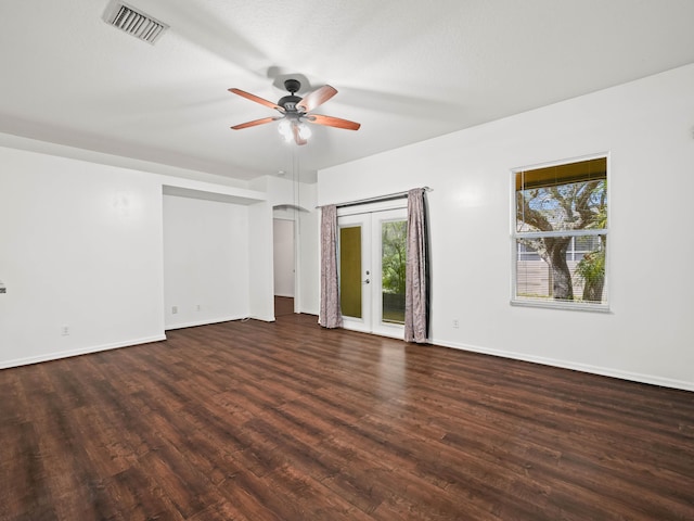 empty room featuring french doors, wood finished floors, visible vents, and baseboards