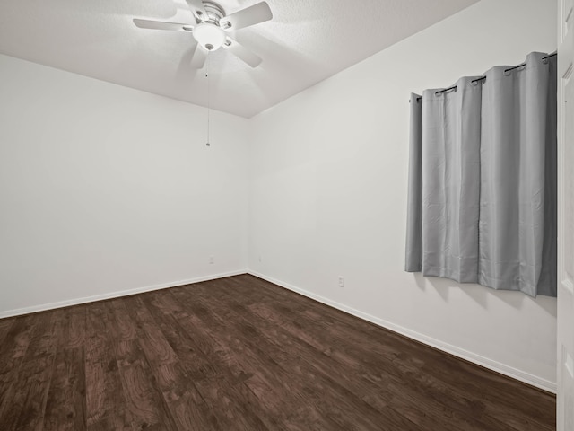 unfurnished room featuring dark wood-style floors, a textured ceiling, a ceiling fan, and baseboards