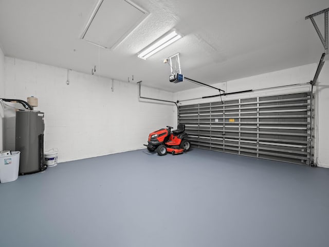 garage featuring concrete block wall, electric water heater, and a garage door opener