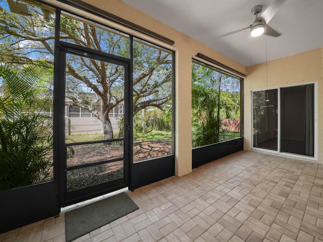 unfurnished sunroom featuring a ceiling fan