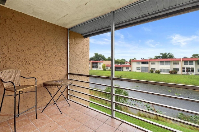 balcony with a residential view and a water view