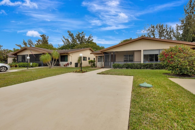 ranch-style house featuring a front lawn and concrete driveway