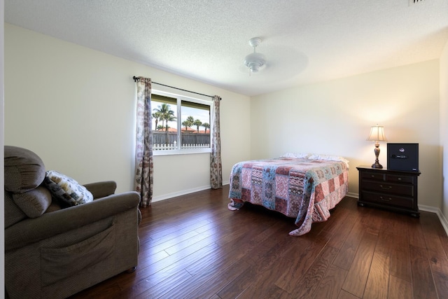 bedroom featuring a ceiling fan, wood-type flooring, a textured ceiling, and baseboards