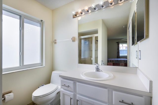 bathroom featuring a stall shower, vanity, and toilet