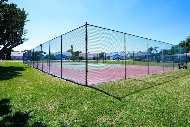 view of sport court featuring fence and a yard