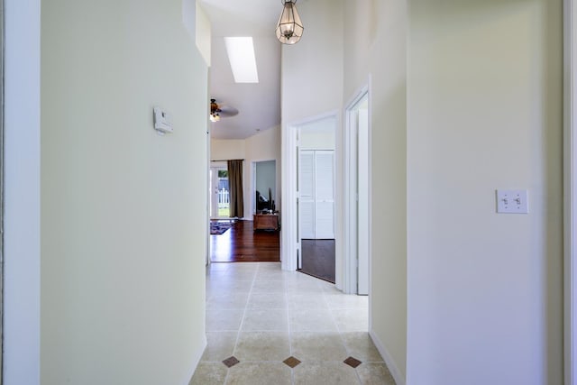 hall with light tile patterned flooring and baseboards